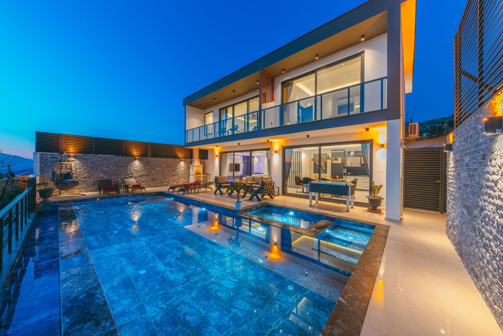 Backyard pool beside a modern home at dusk
