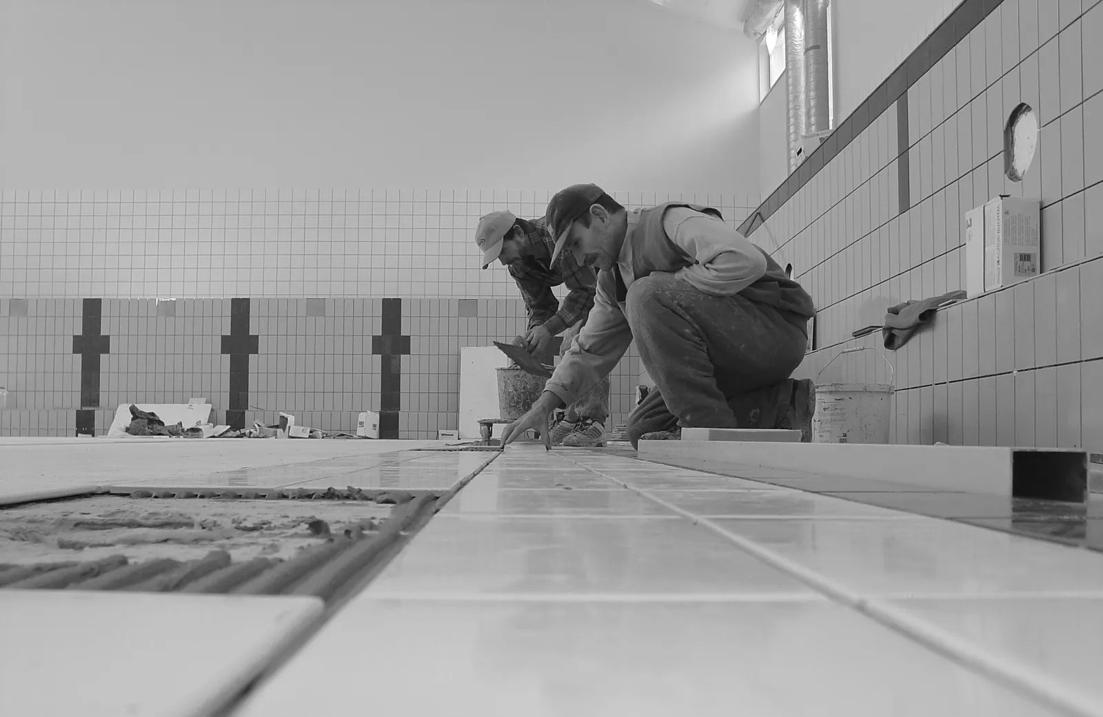 Workers installing tile during pool construction